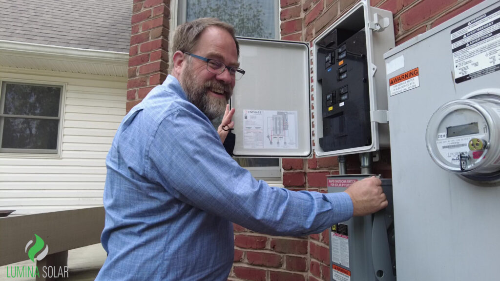 Lumina Solar customer in front of his electrical box about to flip the switch to generate solar energy!