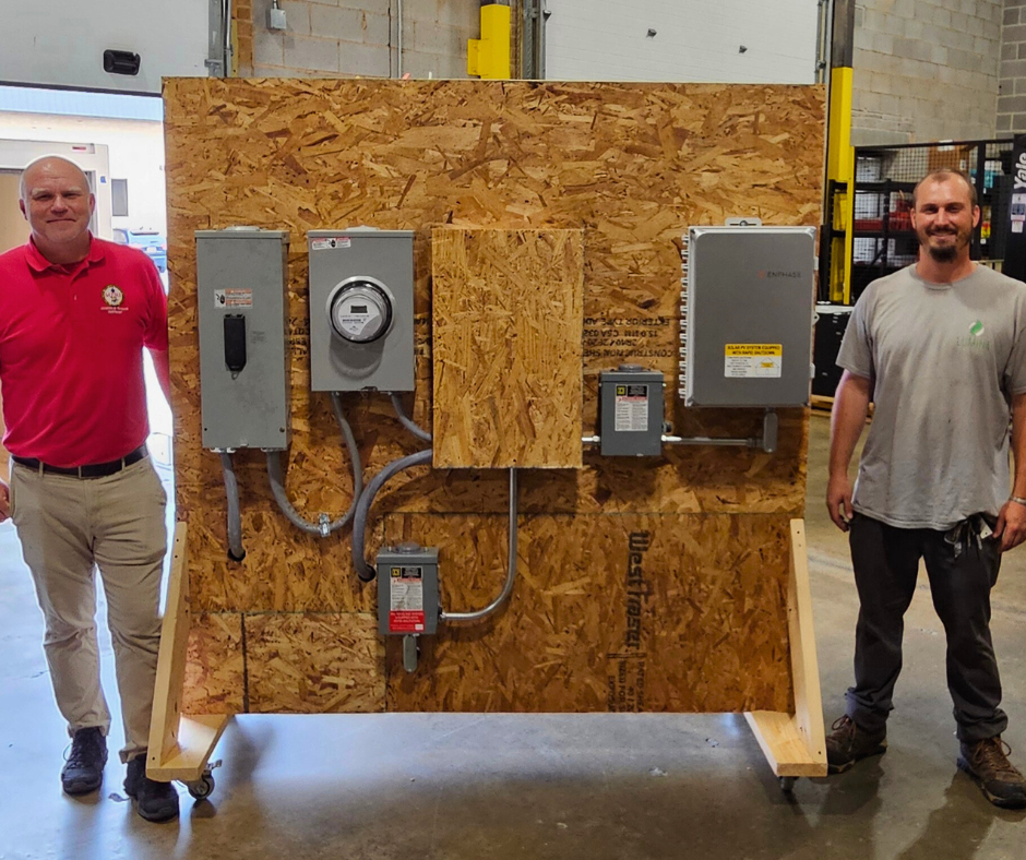 Lumina and MD Fire & Rescue representatives in front of mock solar electrical display